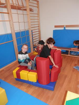 Eine Gruppe von Kindern, die auf einer bunten Spielstruktur sitzen