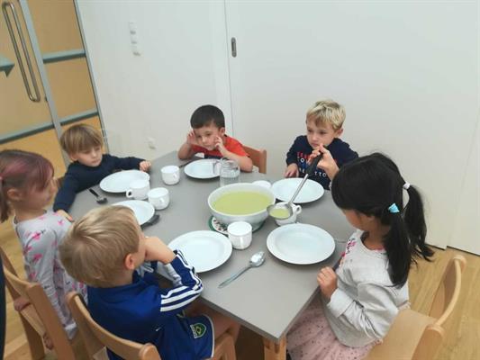 Eine Gruppe von Kindern, die an einem Tisch essen